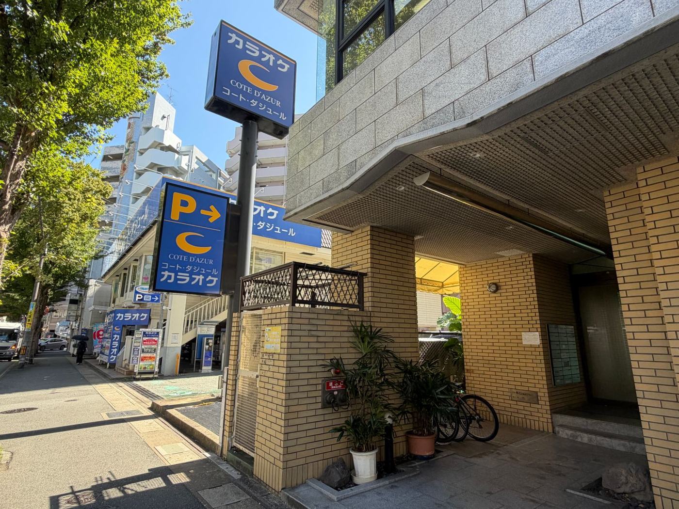 フィット薬院の入口と、隣のカラオケ コート・ダジュールの看板。